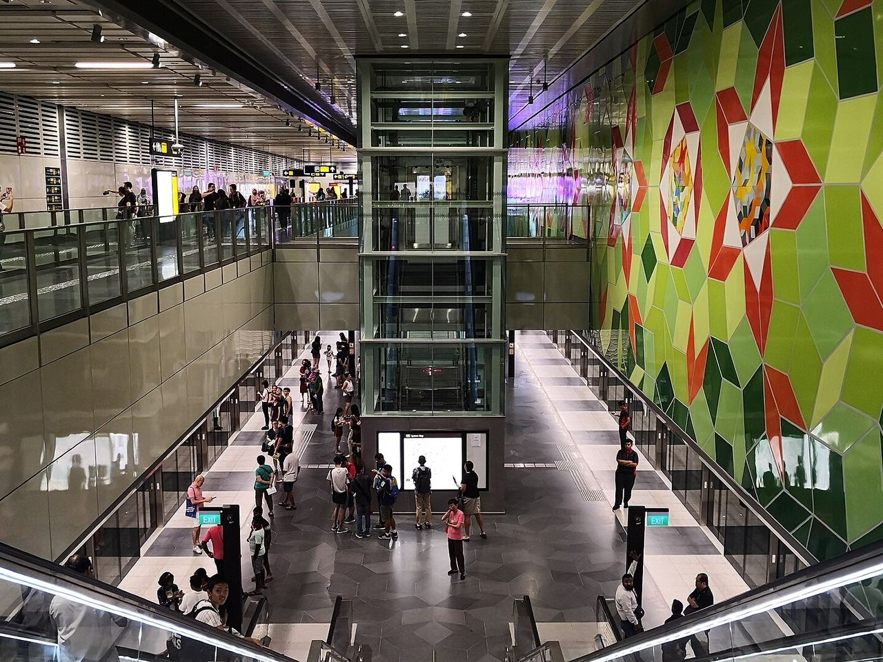 Concourse of Woodlands South MRT station with escalators and commuters